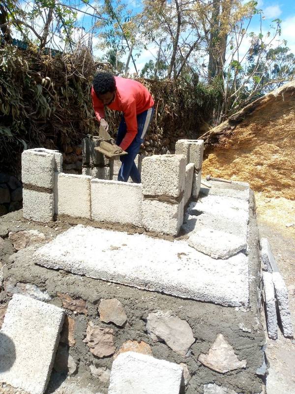 An artisan assembling interlocking wall panels on a finished slab