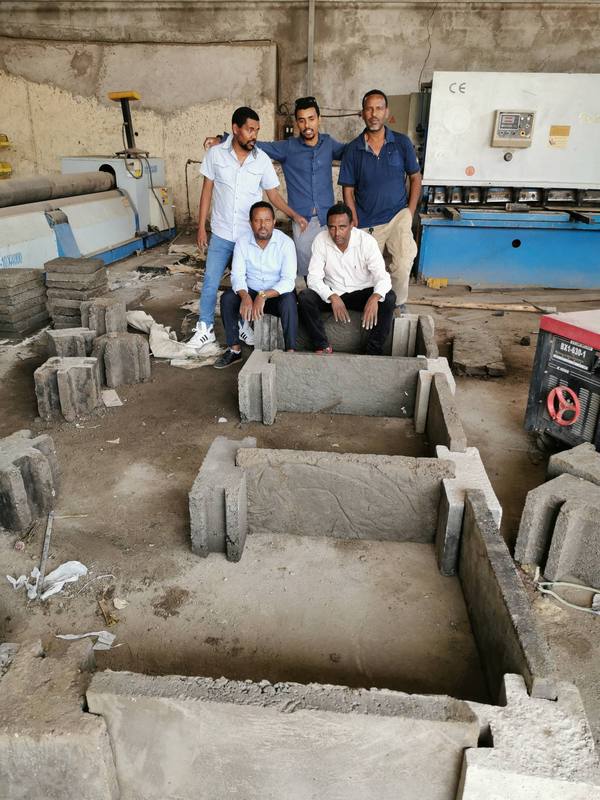 The team with the first interlocking pit-lining and wall components assembled in the workshop