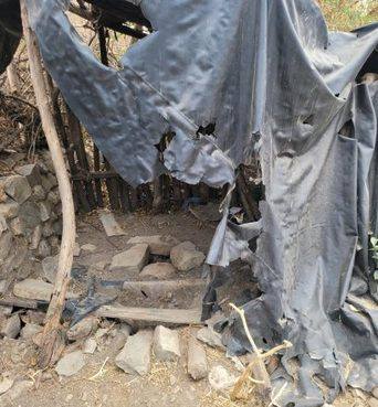 A makeshift latrine built from plastic sheeting and sticks
