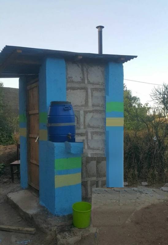 A finished Toilet-in-a-Box with a vent pipe and a hand-washing station
